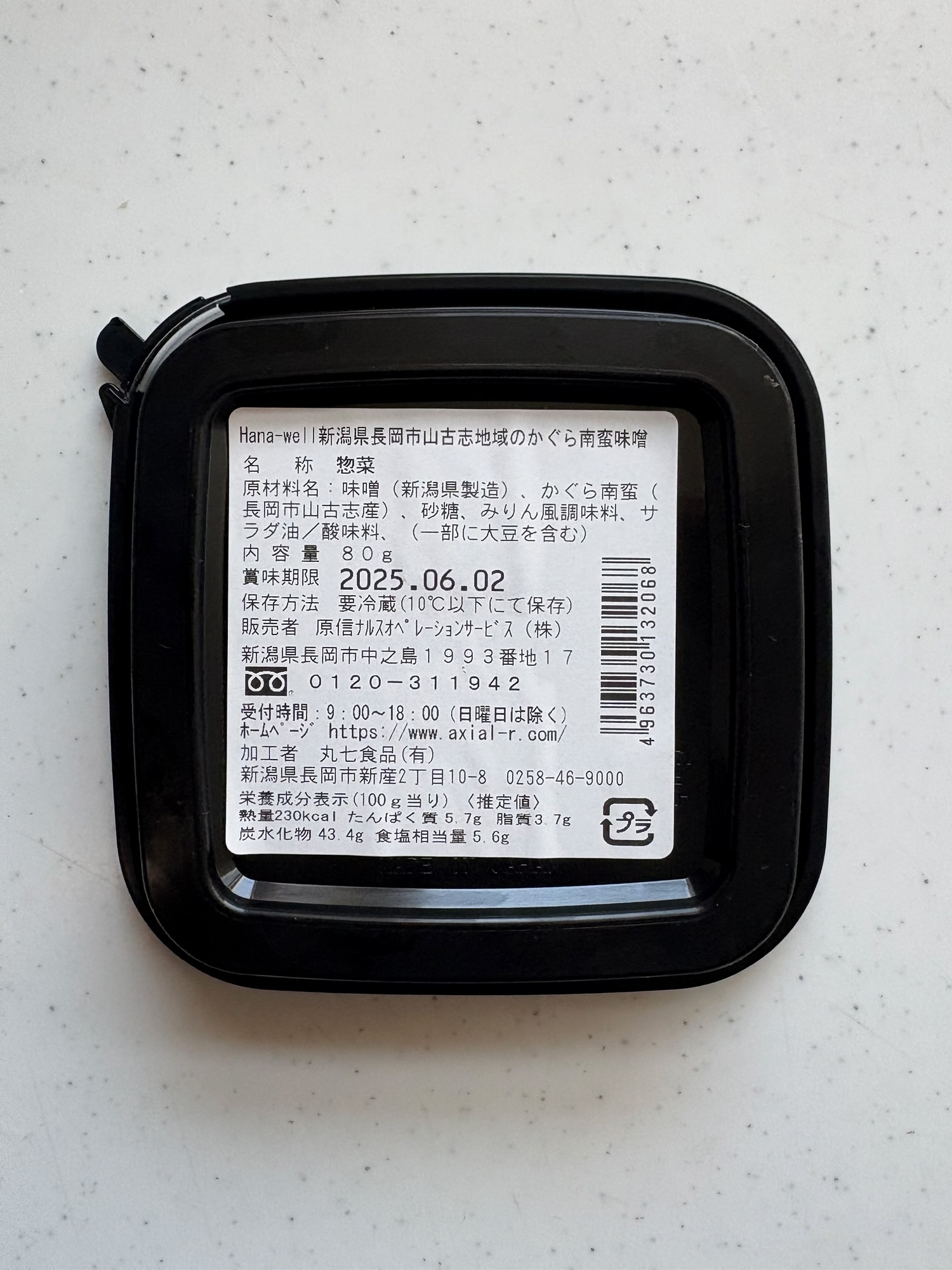 かぐら南蛮味噌の裏面ラベル。原材料に味噌・かぐら南蛮(長岡市山古志産)・砂糖・みりん風調味料が記載され、栄養成分や加工者の丸七食品の住所も明記