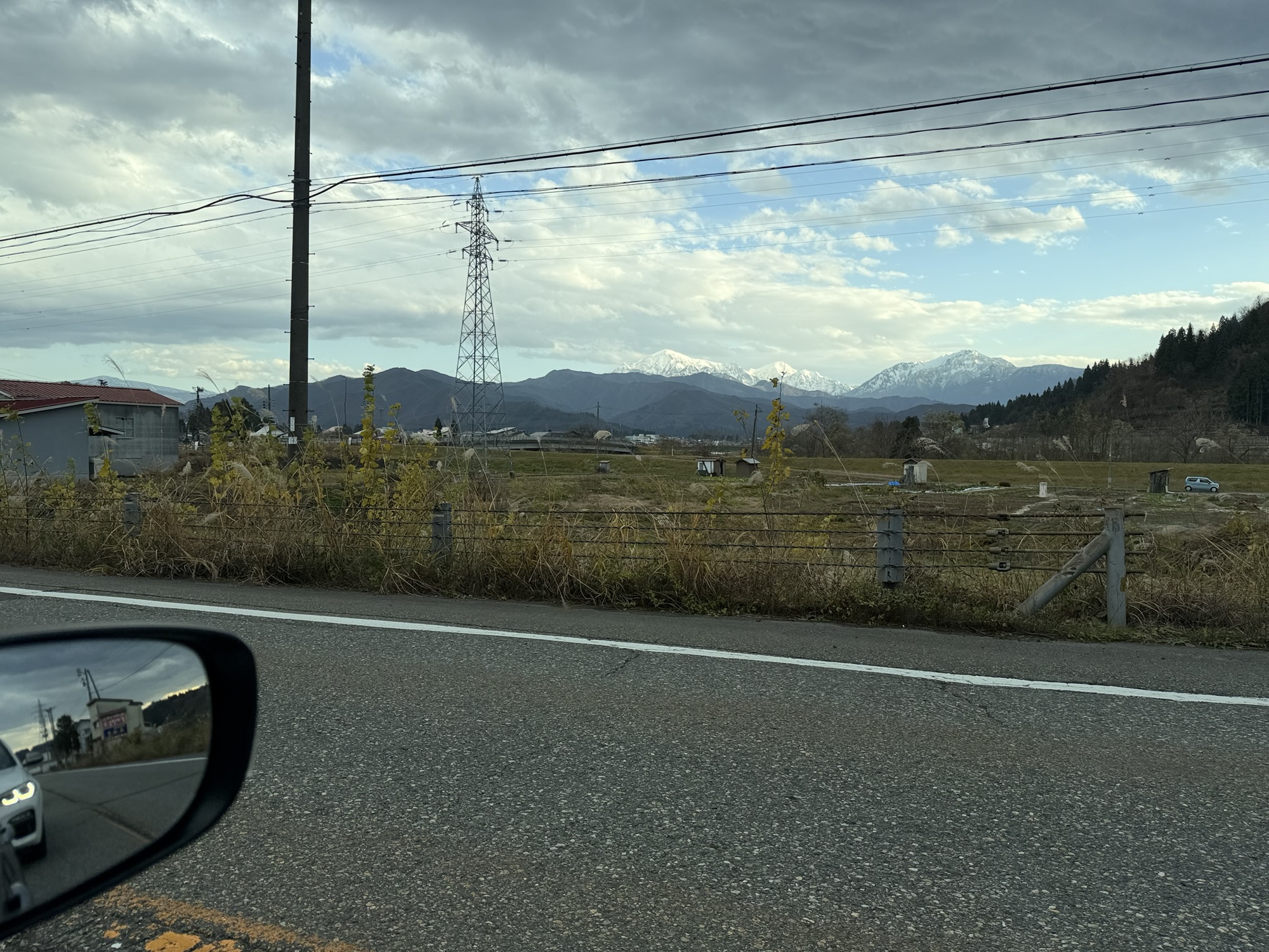国道17号、雪をかぶった山と田園を望むドライブ風景