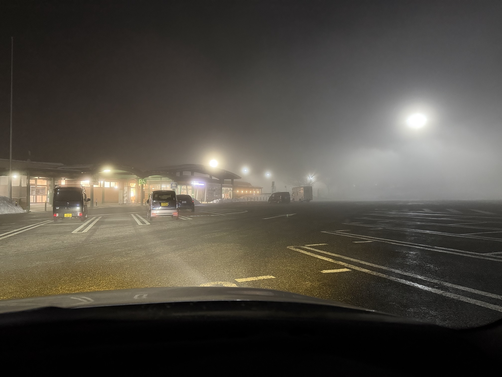 深夜の霧に包まれたSA駐車場