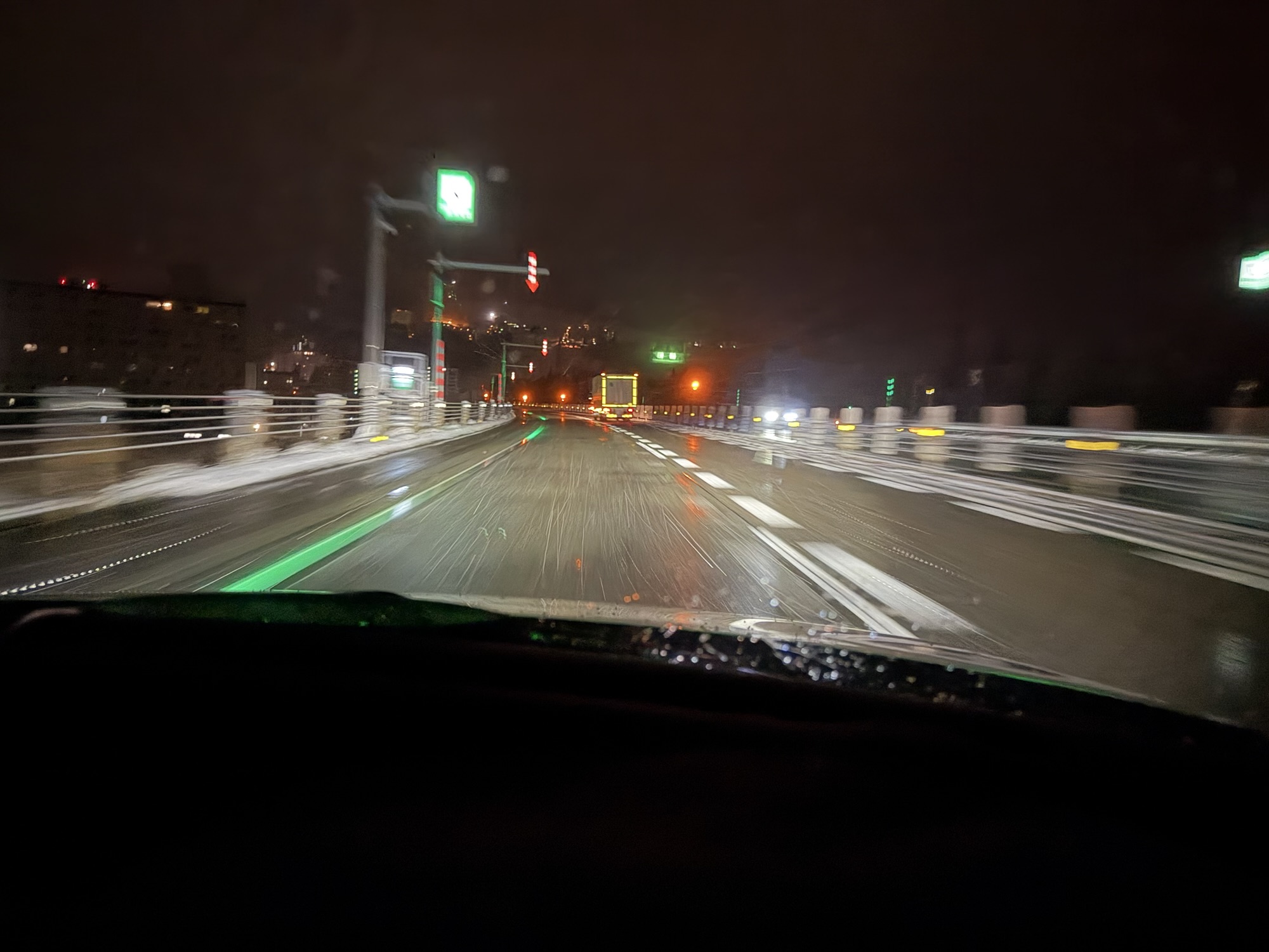 夜間の雪道高速道路。白線の代わりにグリーンLEDで走行車線が表示されている