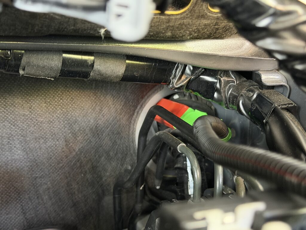 スイフトのエンジンルーム側グロメットに内張り剥がし工具でプラス線を通す