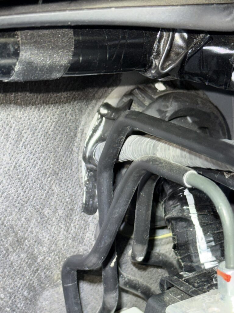 エンジンルーム側のグロメット貫通部(テープ養生済み)