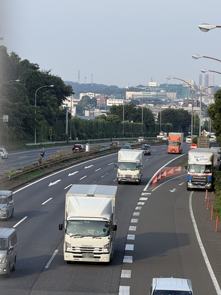 橋の上から見た東名高速を走る大型トラック
