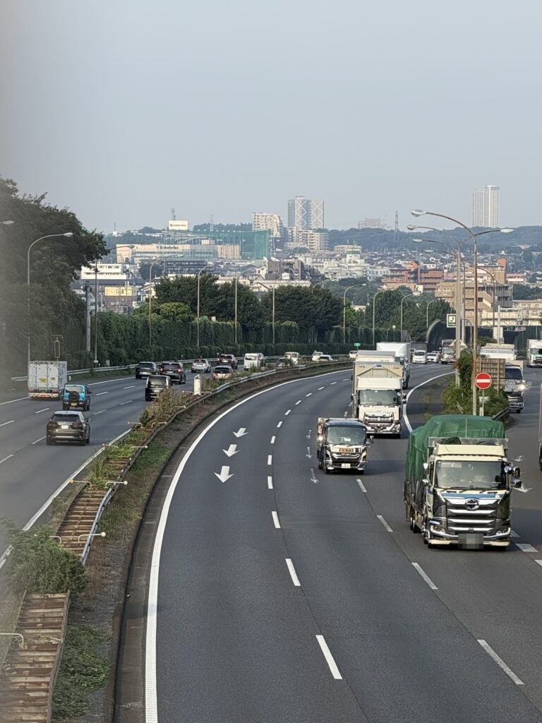 橋の上から見た東名高速のカーブと市街地の遠景