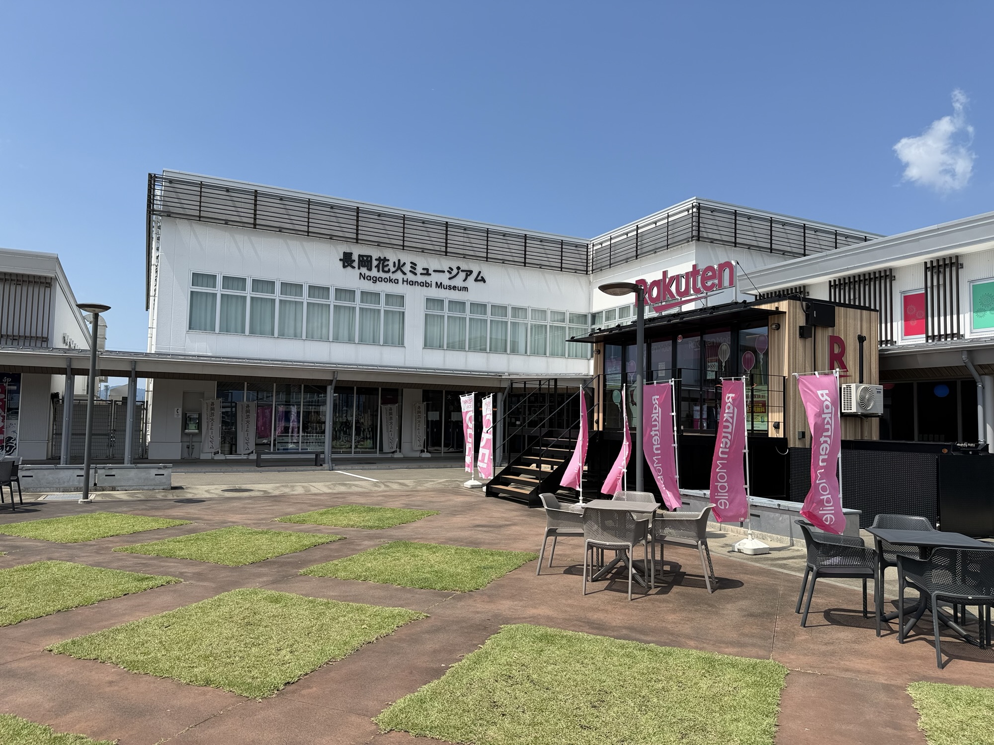 芝生の市松模様広場と施設外観